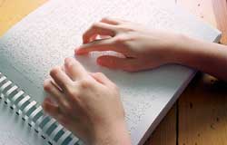 Photo of hands reading a braille book