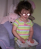Photo of a little girl exploring a print-and-braille book