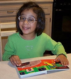 Photo of Torrie reading one of her books from Seedlings