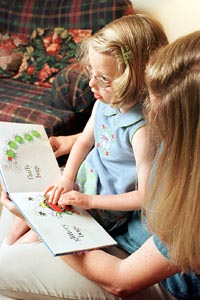 Photo of Kat exploring a Print-and-Braille Book with her mom