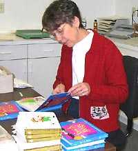 Photo of a Seedlings volunteer assembling print-and-braille books