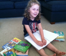 Photo of Lizzy reading a Print-&-Braille Book