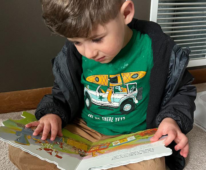 Image of Ezra Orduna reading a braille book.