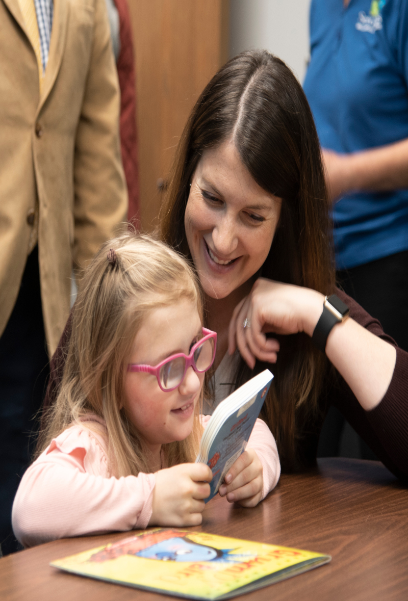 Photo of Ann with her daughter Avery observing a seedlings book