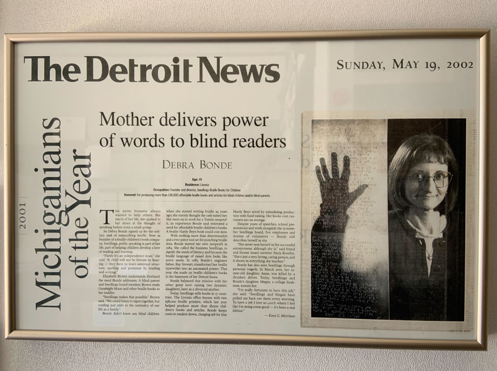A photo of a framed newspaper article celebrating Seedlings' founder as Michiganian of the Year.
