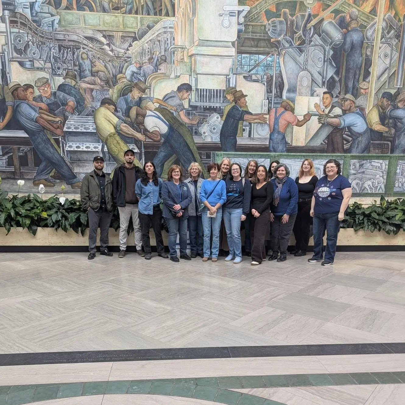 A group of Seedlings staff posing in front of a mural at the Detroit Institute of Arts